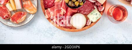 Panorama aus Wurstwaren und Käse mit Rosenwein, Oliven und einem von oben aufgenommenen Textort. Spanische Tapas oder italienische Antipasti. Lachs-Sandwiches, blauer und Ziegenkäse, Jamon Stockfoto