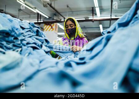 Dhaka, Bangladesch. August 2021. Ready Made Garment (RMG)-Arbeiter, die während ihres Arbeiters Gesichtsmasken tragen, als Vorsichtsmaßnahme gegen die Ausbreitung des Corona-Virus. (Foto von Sultan Mahmud Mukut/SOPA Image/Sipa USA) Quelle: SIPA USA/Alamy Live News Stockfoto