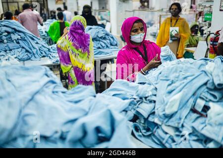 Dhaka, Bangladesch. August 2021. Ready Made Garment (RMG)-Arbeiter, die während ihres Arbeiters Gesichtsmasken tragen, als Vorsichtsmaßnahme gegen die Ausbreitung des Corona-Virus. (Foto von Sultan Mahmud Mukut/SOPA Image/Sipa USA) Quelle: SIPA USA/Alamy Live News Stockfoto