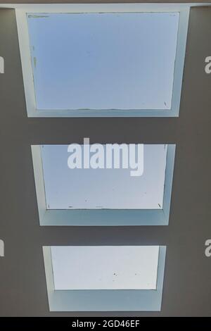 fenster in einem Eckgebäude mit Blick auf den blauen Himmel Stockfoto