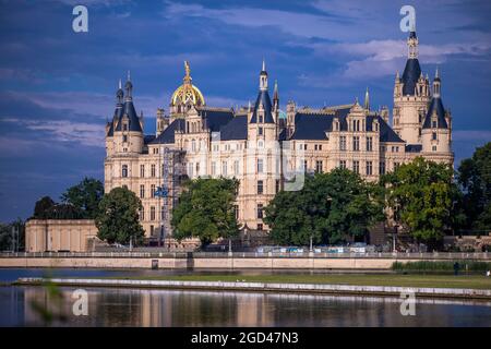 Schwerin, Deutschland. August 2021. Nach einem Gewitter ziehen dunkle Wolken über das Schweriner Schloss. Der Sitz des landtags von Mecklenburg-Vorpommern spiegelt sich im Burgsee wider. Quelle: Jens Büttner/dpa-Zentralbild/dpa/Alamy Live News Stockfoto