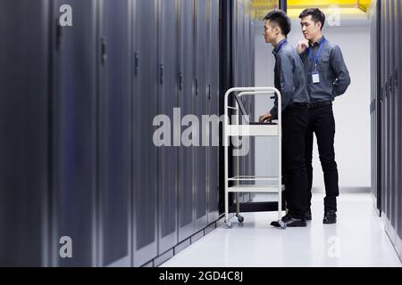 Techniker, die Wartungsarbeiten im Computerraum durchführen Stockfoto