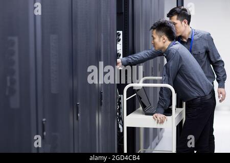 Techniker, die Wartungsarbeiten im Computerraum durchführen Stockfoto