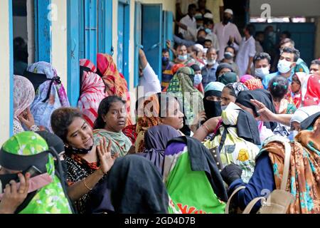 Nicht exklusiv: DHAKA, BANGLADESCH - 10. AUGUST: Personen warten in der Warteschlange, um den Impfstoff gegen Covid-19 im Asrafabad High Schoo zu erhalten, während Stockfoto