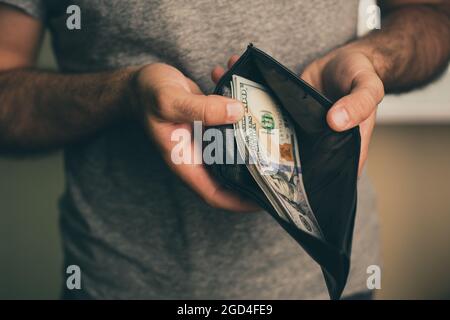 Mann schaut in die Brieftasche. Bargeld. Wohlhabender Mann, der sein Geld zählt. Nahaufnahme. Stockfoto