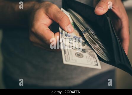 Mann schaut in die Brieftasche. Bargeld. Wohlhabender Mann, der sein Geld zählt. Nahaufnahme. Stockfoto