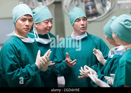 Medizinisches Team diskutiert im Operationsraum Stockfoto