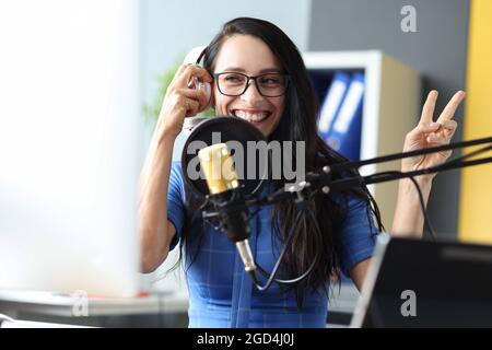 Die junge Radiomoderatorin arbeitet im Studio, sie lächelt und sendet Ansagen aus der Nähe Stockfoto