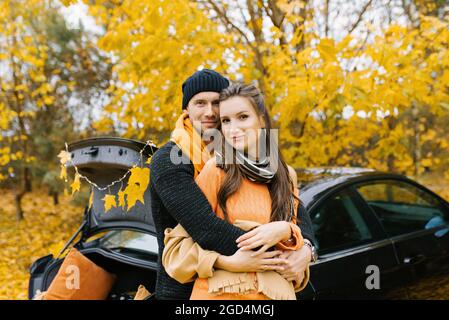 Ein junges verliebter Pärchen umarmt sich im Herbstwald, geht spazieren und genießt die Natur Stockfoto