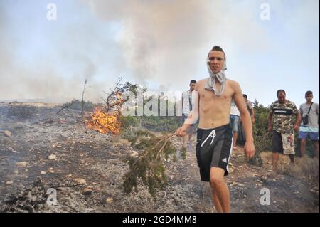 Bizerte, Tunesien. August 2021. Der zweite Tag des Feuers auf dem Berg Ennadhour in Bizerte (60 km nördlich von Tunis). Die jungen Bewohner der Region versuchen, das Feuer mit ihren Händen zu kontrollieren, um zu verhindern, dass sich das Feuer auf andere Gebiete ausbreitet und den Schaden minimiert. © Chokri Mahjoub/ZUMA-Pressdraht) Stockfoto