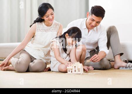 Junge Familie spielt im Wohnzimmer einen Baustein Stockfoto