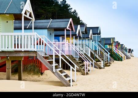 Bunte Holzstrandhütten auf Stelzen bei Wells-next-the-Sea an der Nordküste von Norfolk, England, Großbritannien. Stockfoto