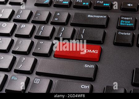Rote OMG-Taste auf einer schwarzen pc-Tastatur. Desktop-Tastatur mit OMG Gamer-Slang-Taste. Enter-Taste mit oh mein gott Spiel Abkürzung. Akronyme für den Gamer-Chat. Stockfoto