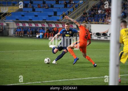 DNIPRO, UKRAINE - 7. AUGUST 2021 - der Stürmer Artem Dovbyk (L) vom SC Dnipro-1 und der Verteidiger Stanislav Mykytsei vom FC Mariupol sind während des Th in Aktion Stockfoto