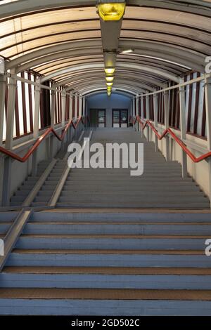 Treppe in einer überdachten Galerie mit Geländern und einer Rollstuhlrampe vertikale Ausrichtung Stockfoto