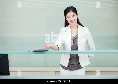 Geschäftsfrau begrüßt an der Rezeption Stockfoto