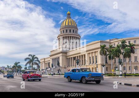 Havanna, Kuba - 11. Januar 2021; Blauer und roter Oldtimer vor dem Capitolio in Havanna. Stockfoto