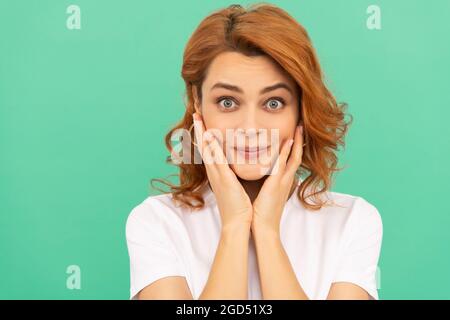 Erstaunt Rotschopf Mädchen mit perfekter Haut und lockiges Haar auf blauem Hintergrund, Porträt der Schönheit Stockfoto