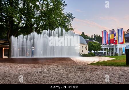 Menschen am Wasserpavillon des dänischen Künstlers Jeppe Hein bei Sonnenuntergang vor dem Kurhaus in Baden-Baden. Stockfoto