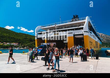 Poros, Insel Cefalonia, Griechenland - Juli 17 2019: Ausschiffung von Autos und Passagieren von der Fähre der Levante Ferries Group, die im Hafen von Poros angedockt ist. Heller Sommertag, Reisekonzept. Stockfoto