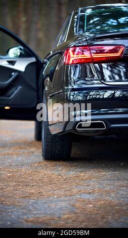 GRODNO, WEISSRUSSLAND - DEZEMBER 2019: Audi A6 4G, C7 2016 Rücklicht eines schwarz-metallischen Autos auf der linken Seite, Nahaufnahme mit geöffneter Tür, außer Fokus auf Wald Stockfoto