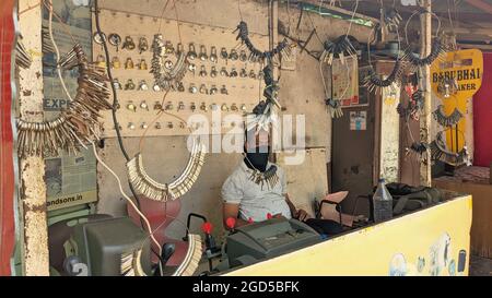 HYDERABAD, INDIEN - 03. März 2021: Ein kleines Schlossergeschäft mit Schlüsselbeinen, die an kleinen Haken auf der Straße aufgehängt wurden Stockfoto