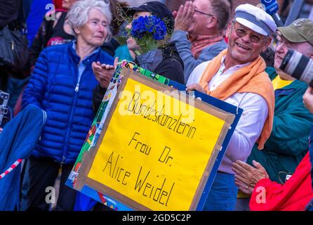 Schwerin, Deutschland. August 2021. Eine AfD-Unterstützerin hält ein Plakat mit der Aufschrift "Bundeskanzlerin Dr. Alice Weidel" und steht zu Beginn der Wahlkampftour der AfD vor der Bühne. In den jüngsten Wählerumfragen lag die AfD bei zehn bis elf Prozent. Die Partei geht mit dem Slogan "Deutschland" in den Wahlkampf. Aber normal.“ in den Wahlkampf. Quelle: Jens Büttner/dpa-Zentralbild/ZB/dpa/Alamy Live News Stockfoto