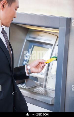Geschäftsmann mit Geldautomat mit Bankkarte Stockfoto