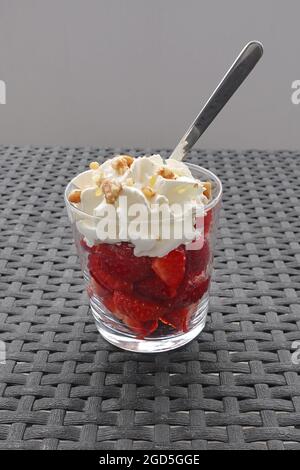 Erdbeeren mit Schlagsahne und Walnüssen. Früchtedessert. Stockfoto