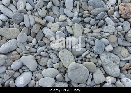 Kieselsteine am felsigen Strand. Steine und kleine Felsen Hintergrund. Stockfoto
