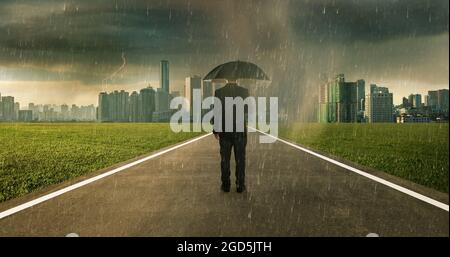 Kaufmann unter Sturm Regen mit Regenschirm, Risiko und Krise-Konzept. Stockfoto