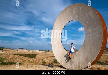 Volterra, Toskana, Italien. August 2020. Auf dem Land der Stadt lenkt eine Installation moderner Kunst die Aufmerksamkeit auf die toskanische Landschaft. Eine junge Tour Stockfoto