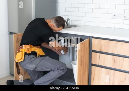 Mann Installation der Küche tippen und das Waschbecken Stockfoto