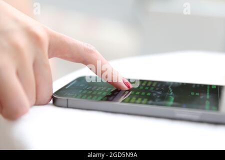 Weibliche Hand mit Smartphone Aktien online im Coffee Shop Business Concept handeln Stockfoto