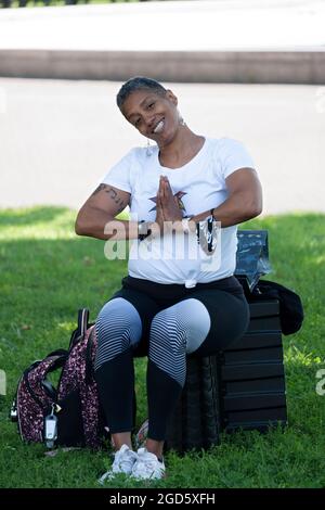 Porträt eines Yoga- und Wellnesslehrers mittleren Alters, der eine Klasse im Flushing Meadows Corona Park in Queens unterrichtet. Stockfoto