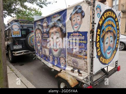 Ein SUV und Trailer mit farbenfrohen Anzeigen für Payasito Chiquitin, einen spanischsprachigen Clown, Zauberer und Entertainer. In Astoria, Queens, New York. Stockfoto