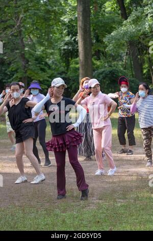 Eine Gruppe asiatischer amerikanischer Frauen mittleren Alters bei einem Tanzkurs in einem Park in Queens, New York. Stockfoto