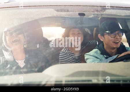 Eine Gruppe glücklicher asiatischer Freunde, die eine Besichtigungstour mit dem Auto genießen Stockfoto