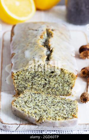 Zitronenkuchen mit Mohnsamen, bedeckt mit Glasur auf hellem Hintergrund. Stockfoto