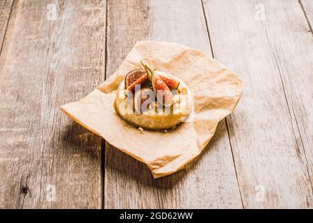 Gebackener Camembert-Käse mit Feigen, Walnüssen, Honig und Thymian auf dem rustc-Hintergrund. Selektiver Fokus. Geringe Schärfentiefe. Stockfoto