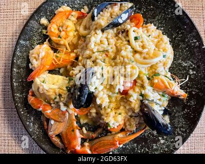 Italienisches Risotto mit Garnelen, Muscheln, Oktopus, Muscheln und Tomaten Stockfoto