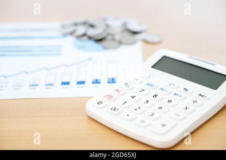 Rechner und Stapel von Münzen Stockfoto
