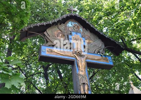 Orthodoxes Kreuz auf dem Hintergrund der grünen Populationen. Moskau, Russland. Stockfoto