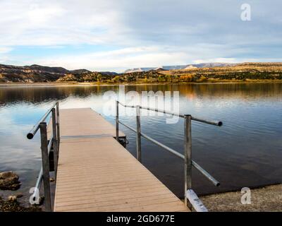 An einem ruhigen Herbstmorgen blickt man auf den Pier, hinaus in Richtung des Wide Hollow Reservoir, im Petrified Forest State Park, Escalante, Utah, USA. Stockfoto