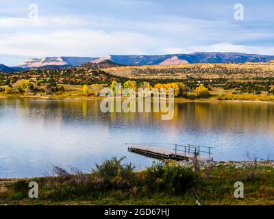 Morgenblick über den weiten hohlen Stausee, Escalante, Utah, USA, mit Fremonts Cottonwood im Herbstlaub, auf dem gegenüberliegenden Ufer Stockfoto