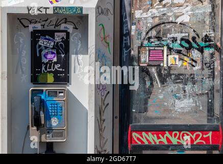 Vandalisierte öffentliche Telefone, Graffiti über Telefonzellen, beschädigte Telefonzellen, öffentliche Telefone, die mit Graffiti bedeckt sind und zerbrochene, sprühlackierte Boxen. Stockfoto