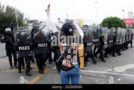 Ein Protestler hebt während der Demonstration ihren dreifingerigen Gruß vor den Bereitschaftspolizisten. Die Polizei feuerte Tränengas und Gummigeschosse, um einen weiteren regierungsfeindlichen Protest in Bangkok zu zerstreuen. Die von der Tha Lu Fah-Gruppe organisierte Demonstration begann um 15:00 Uhr am Victory Monument, Demonstranten warfen Farbe auf eine Reihe von Bereitschaftspolizisten, die sie konfrontierten, als sie versuchten, zum Wohnsitz des Premierministers Prayut Chan-o-cha beim 1. Infanterie-Regiment in der Vibhavadi Rangsit Road zu marschieren. (Foto von Chaiwat Subprasom/SOPA Images/Sipa USA) Stockfoto