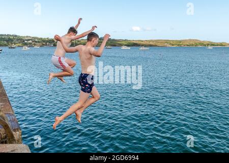 Schull, West Cork, Irland. August 2021. Die Sonne schien heute in Schull, was viele Einheimische und Urlauber hervorbrachte. In Schull Harbor kühlten sich Andrew Murray und Paddy Walsh aus Cork City ab. Quelle: AG News/Alamy Live News Stockfoto