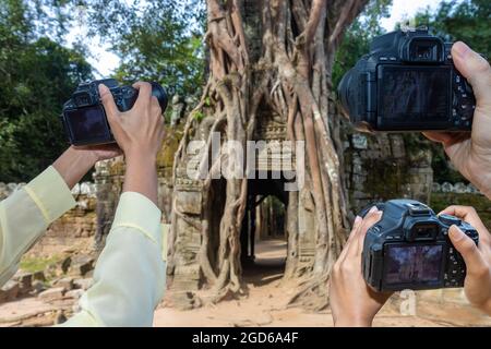 Eine Hand von Touristen mit Kameras, die Fotos im Khmer Angkor Tempelkomplex, Kambodscha, machen. Stockfoto