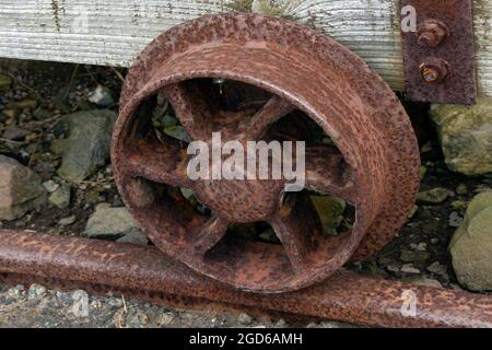 Rostiges Rad auf einem alten Lastwagen mit Kupferminen in einer verlassenen Mine an der Kupferküste in der Grafschaft Waterford, Irland. Stockfoto